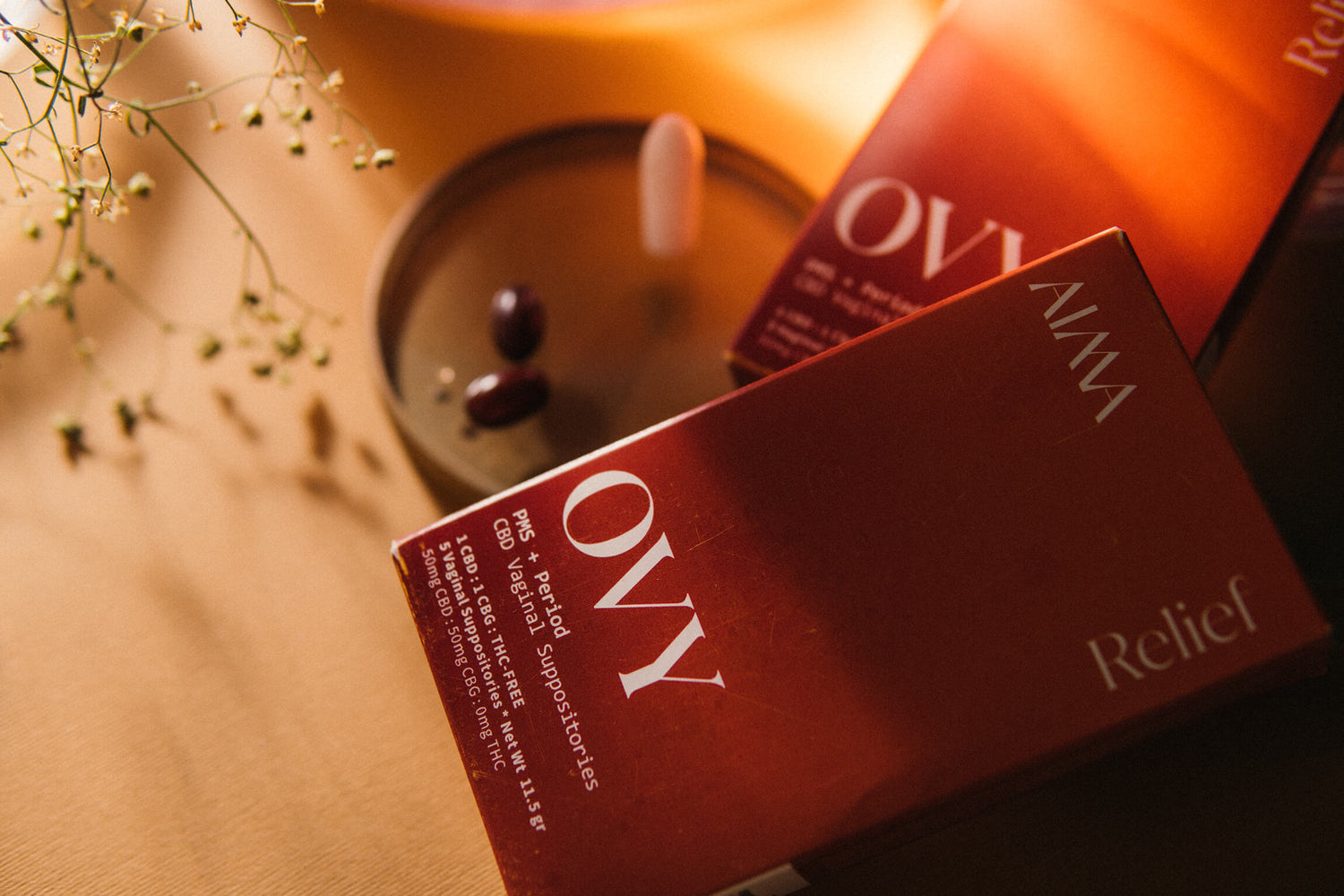 Image of OVY RELIEF product for period pain box under soft orange mood lighting. 